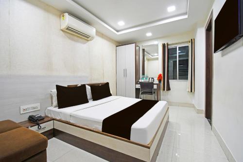 a hotel room with a bed and a desk at Super Townhouse Sahayogi Nagar Near Big Bazaar in Dhanbād