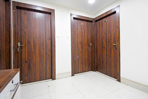 a corridor with two wooden doors in a room at Super Townhouse Sahayogi Nagar Near Big Bazaar in Dhanbād
