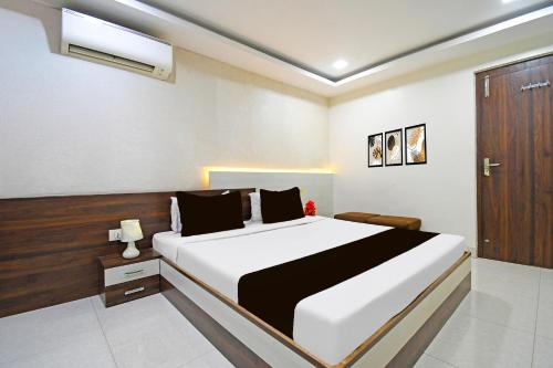a bedroom with a large bed and a wooden door at Super Townhouse Sahayogi Nagar Near Big Bazaar in Dhanbād