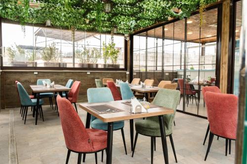 a restaurant with tables and chairs and windows at Parliament Hotel & Restaurant in Baku