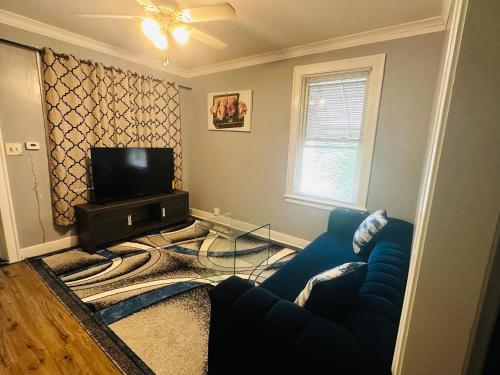a living room with a blue couch and a television at Cozy in Hyde Park Greater Grand Crossing in Chicago