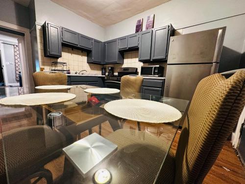 a kitchen with two tables and a refrigerator at Cozy in Hyde Park Greater Grand Crossing in Chicago