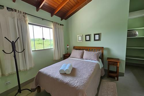 Casa Orquídeas, com piscina aquecida e vista, 3Q في بونيتو: غرفة نوم بها سرير عليه منشفتان