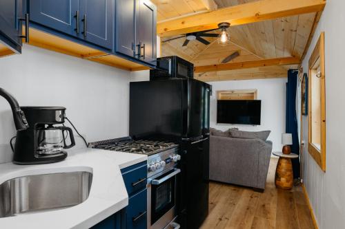 a kitchen with a stove top oven next to a couch at Arbutus Lakeview-Fishing-Pet Friendly-Near TC! in Traverse City