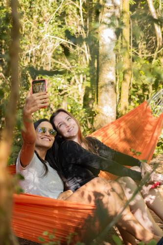 two women laying in a hammock taking a picture at Pousada Rio Gouveia in Brotas