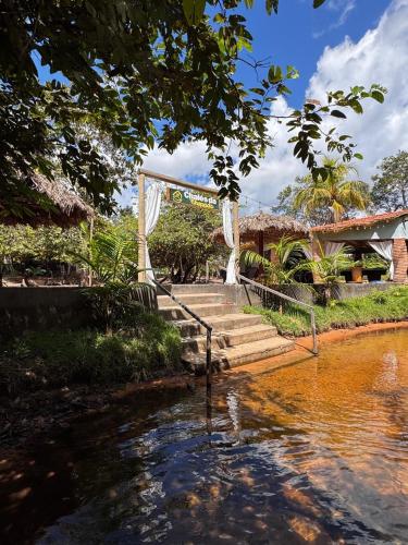 a wedding ceremony in front of a house with a pond at Chalés da Chapada in Carolina
