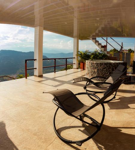 a chair on a balcony with a view of the mountains at Glamping Pedro in San Gil