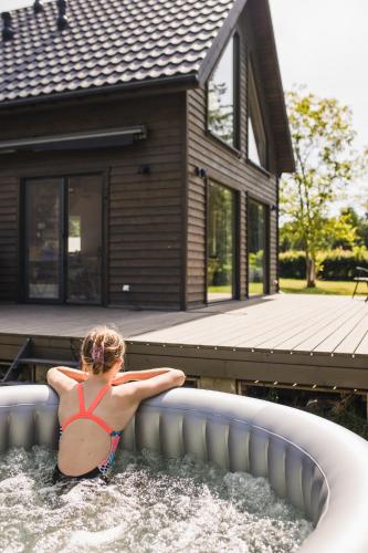 a young girl in the water in a swimming pool at Murawki Dom Blisko Jeziora in Urowo