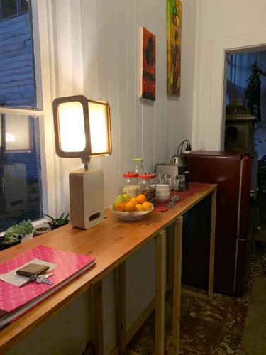 a table with a bowl of fruit and a light on it at Hospedaje en borde río in Valdivia