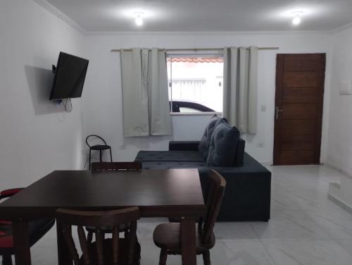 un salon avec une table et un canapé dans l'établissement Casa em Paraty Portão Vermelho, à Parati