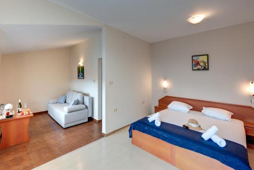 a bedroom with a bed and a chair in it at Семеен хотел Амон Ра in Sozopol