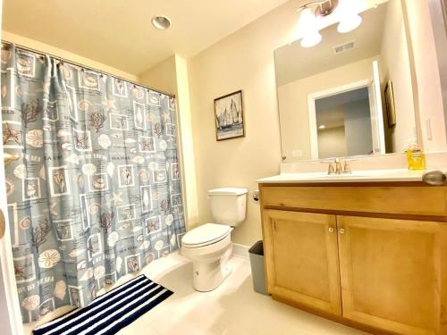 a bathroom with a toilet and a sink and a shower curtain at Venice court 21675 in Dewey Beach