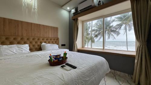 a bedroom with a bed with a view of the ocean at CasaNada Beach Stay in Udupi