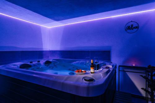 a bathroom with a tub with a bottle of wine at Kuća za odmor KODBA in Štrigova