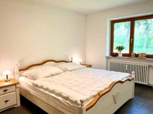 a bedroom with a white bed and a window at Ferienwohnung Almglück mit Pool uns Sauna, direkt am Skilift in Missen-Wilhams