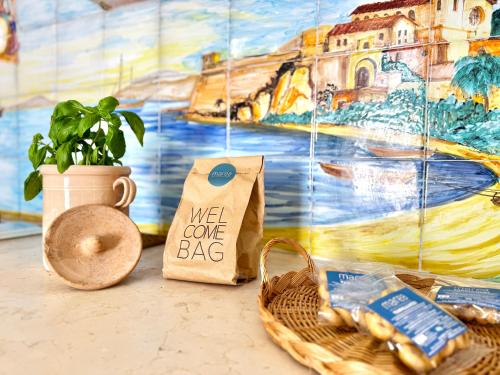 a table with a basket and a wall with a mural at La Torretta - Marea Stays Collection in Otranto
