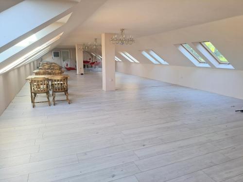 an attic room with a table and chairs and skylights at Parrag Panzió Mátraszentimre in Mátraszentimre