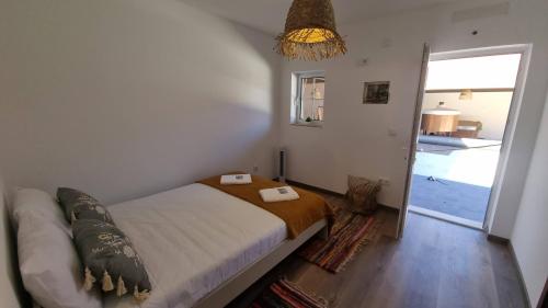 a bedroom with a bed in a room with a window at Eco Charm Discovery Quinta da Oliveirinha in Helenos