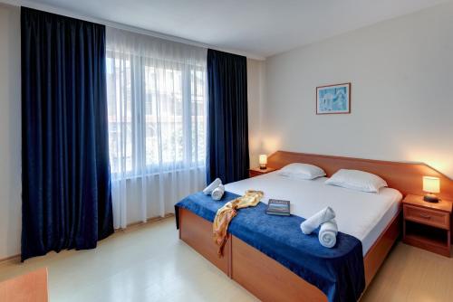 a bedroom with a large bed and a large window at Семеен хотел Амон Ра in Sozopol