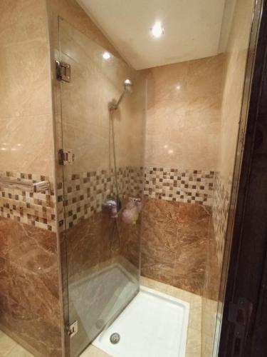 a shower with a glass door in a bathroom at Luxury Apartment Marroco Saidia Cheap in Saidia 