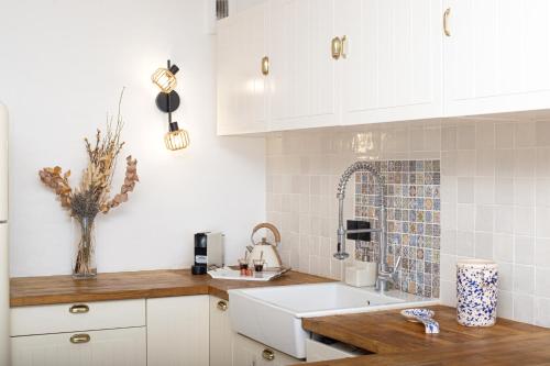 a kitchen with white cabinets and a sink at Le Chevalier in Cap d'Ail