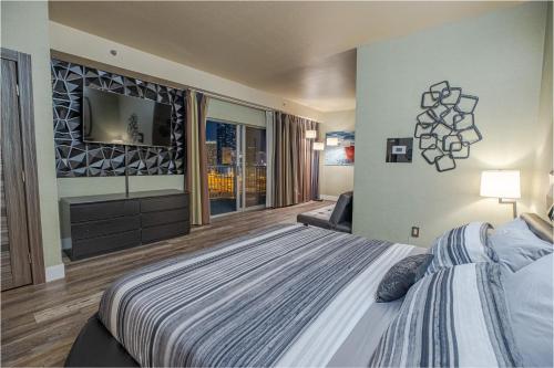 a large bedroom with a bed and a television at 2100 SqFt Penthouse Suite W/ Strip Views! POOL GYM in Las Vegas