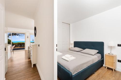 a bedroom with a bed with a blue head board at Le Chevalier in Cap d'Ail