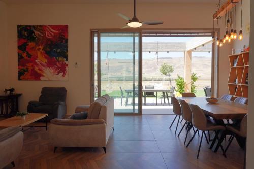 a living room with a table and chairs and a dining room at House in the farm מקום שומר שבת וכשרות in HaZore‘im