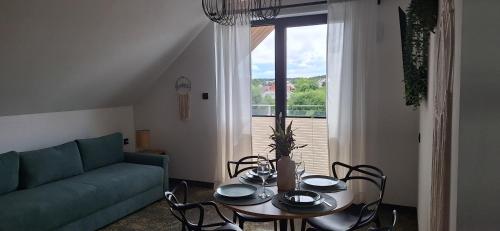 un salon avec une table et un canapé dans l'établissement NA FALI Pokoje i Apartamenty, à Wicie