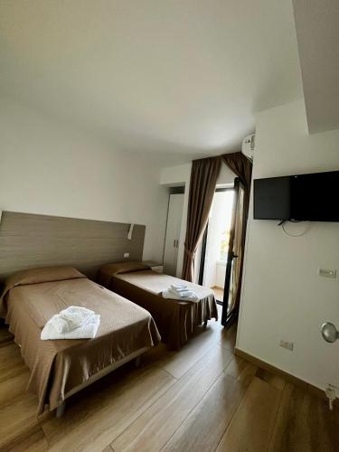 a hotel room with two beds and a television at B&B Mastro Mario in Rocca di Neto