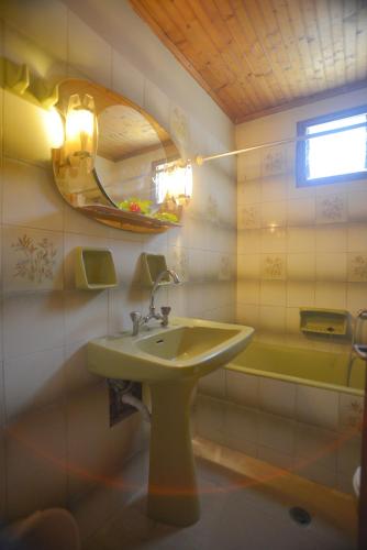 a bathroom with a sink and a mirror and a tub at Alex Katerina Apartments in Peroulades