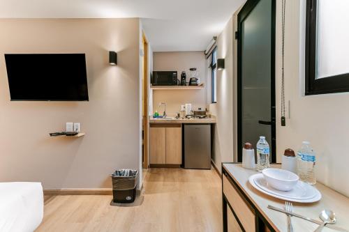 a bathroom with a sink and a tv on the wall at Pájaros By Homirent in Laborcillas