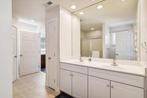 Un baño blanco con dos lavabos y un espejo. en Tingle avenue 624, en Bethany Beach