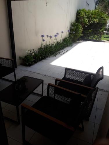 a room with chairs and a patio with plants at Spectacular House in Barrio Sur with a pool in San Miguel de Tucumán