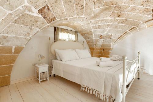 una camera da letto con un letto in un muro di pietra di Dimore Salentine a Felline