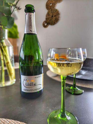 a bottle of wine and a glass on a table at Le grain noble de Wissembourg in Wissembourg