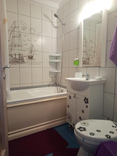 a bathroom with a tub and a sink and a toilet at Modern Beach Apartment in Constanţa