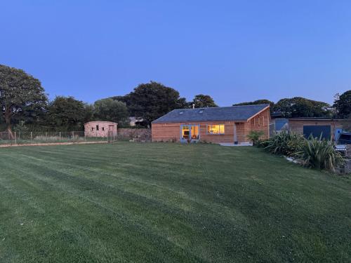 a large yard with a house in the background at Ocean Heart Studio- Luxury, Rural Retreat in Wendron