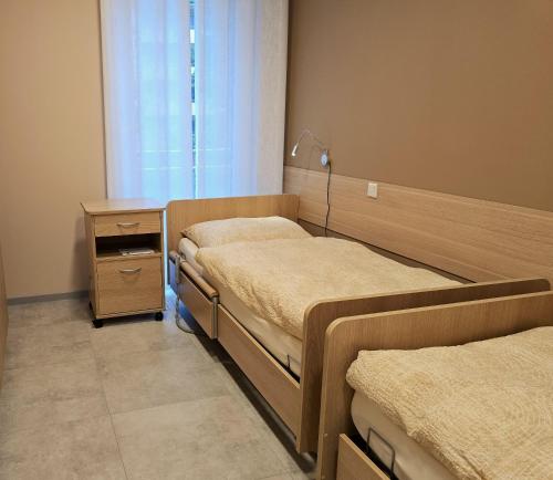 a hospital room with two beds and a window at Pflege- Ferienwohnungen an der Olfe in Ahlen