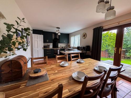 a kitchen and dining room with a wooden table at Whitepark Cottage - your home away from home in Ballycastle