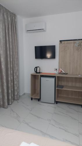 a living room with a tv on a wall with a desk at Vila REJANA in Ksamil