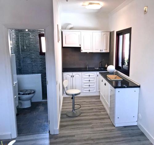 cocina con armarios blancos, lavabo y aseo en Penthouse Valle Gran Rey, en Valle Gran Rey