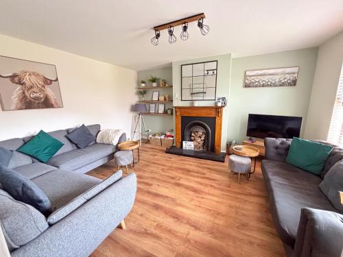 a living room with two couches and a fireplace at Whitepark Cottage - your home away from home in Ballycastle
