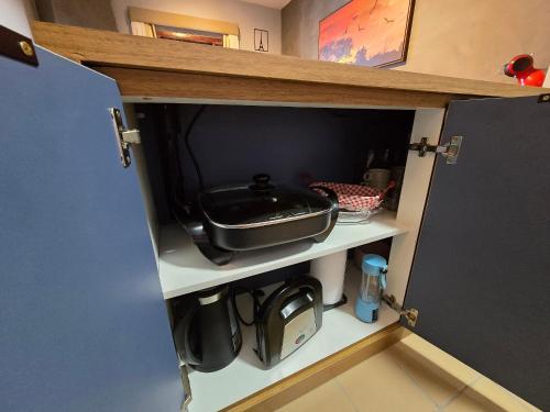 a kitchen cupboard with a pan on top of it at Flat Completo - Piscina aquecida e vista p/ Serra in Campos do Jordão