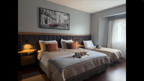 two beds in a bedroom with two lamps on them at Flat Completo - Piscina aquecida e vista p/ Serra in Campos do Jordão
