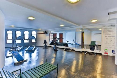 a gym with treadmills and machines in a room at Flat Completo - Piscina aquecida e vista p/ Serra in Campos do Jordão