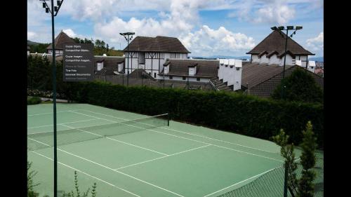 a tennis court in front of a house with at Flat Completo - Piscina aquecida e vista p/ Serra in Campos do Jordão