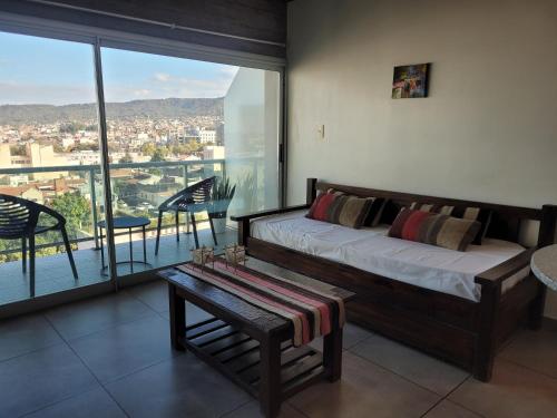 a bedroom with a bed and a balcony with a view at Los Naranjos in San Salvador de Jujuy