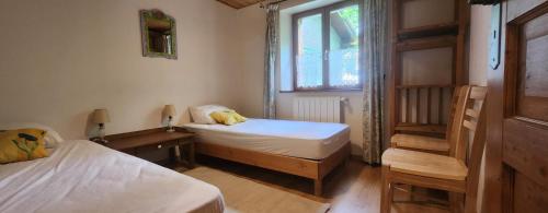 una pequeña habitación con dos camas y una ventana en Garden level - cocooning, en Briançon
