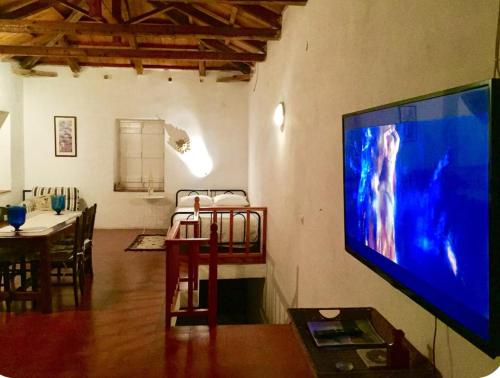 a living room with a large flat screen tv on a wall at Alex Hydra Summerhouse in Hydra